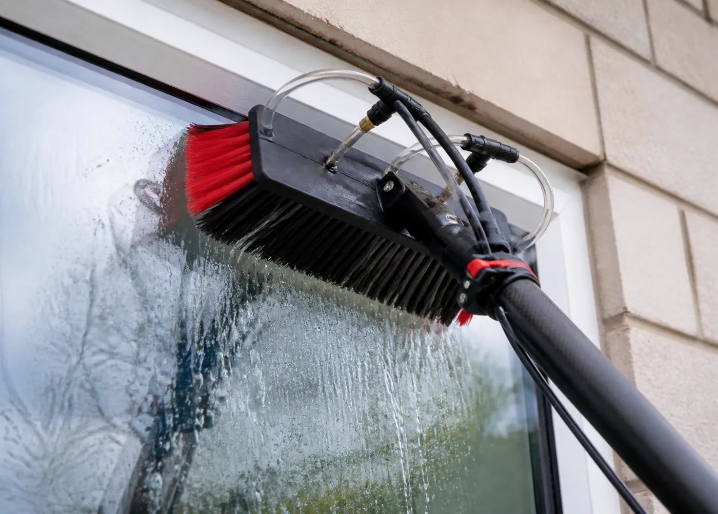 Purified water rinsing a window from a water-fed pole brush